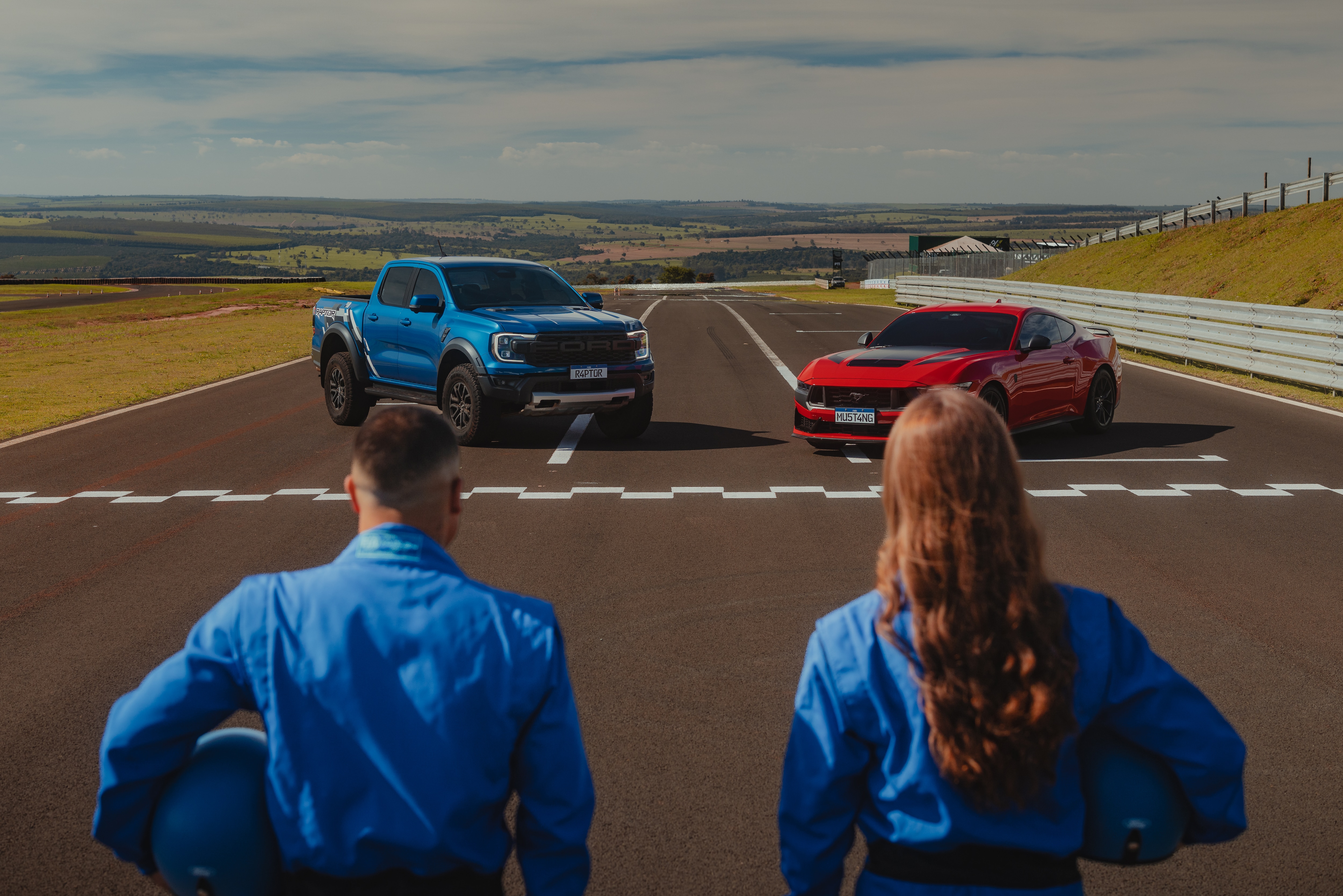 Piloto Rafaela Ferreira e o surfista Ítalo Ferreira na pista com Ford Mustang Dark Horse vermelho e Ford Ranger Raptor azul